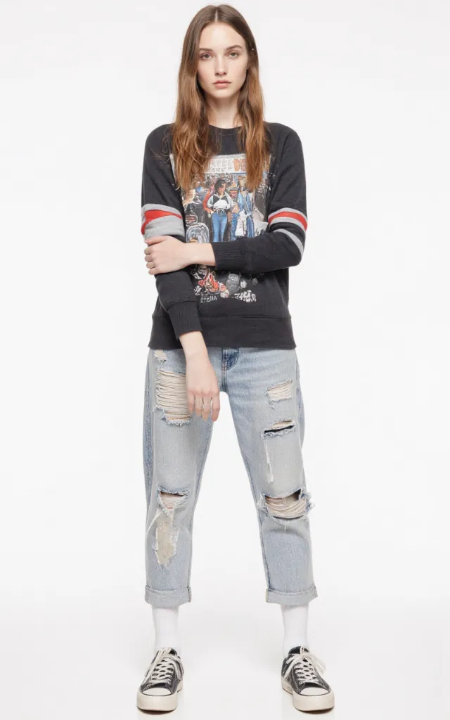 A French female model wearing Street   style clothing, against a white background, in a front   facing shot focusing on shoes